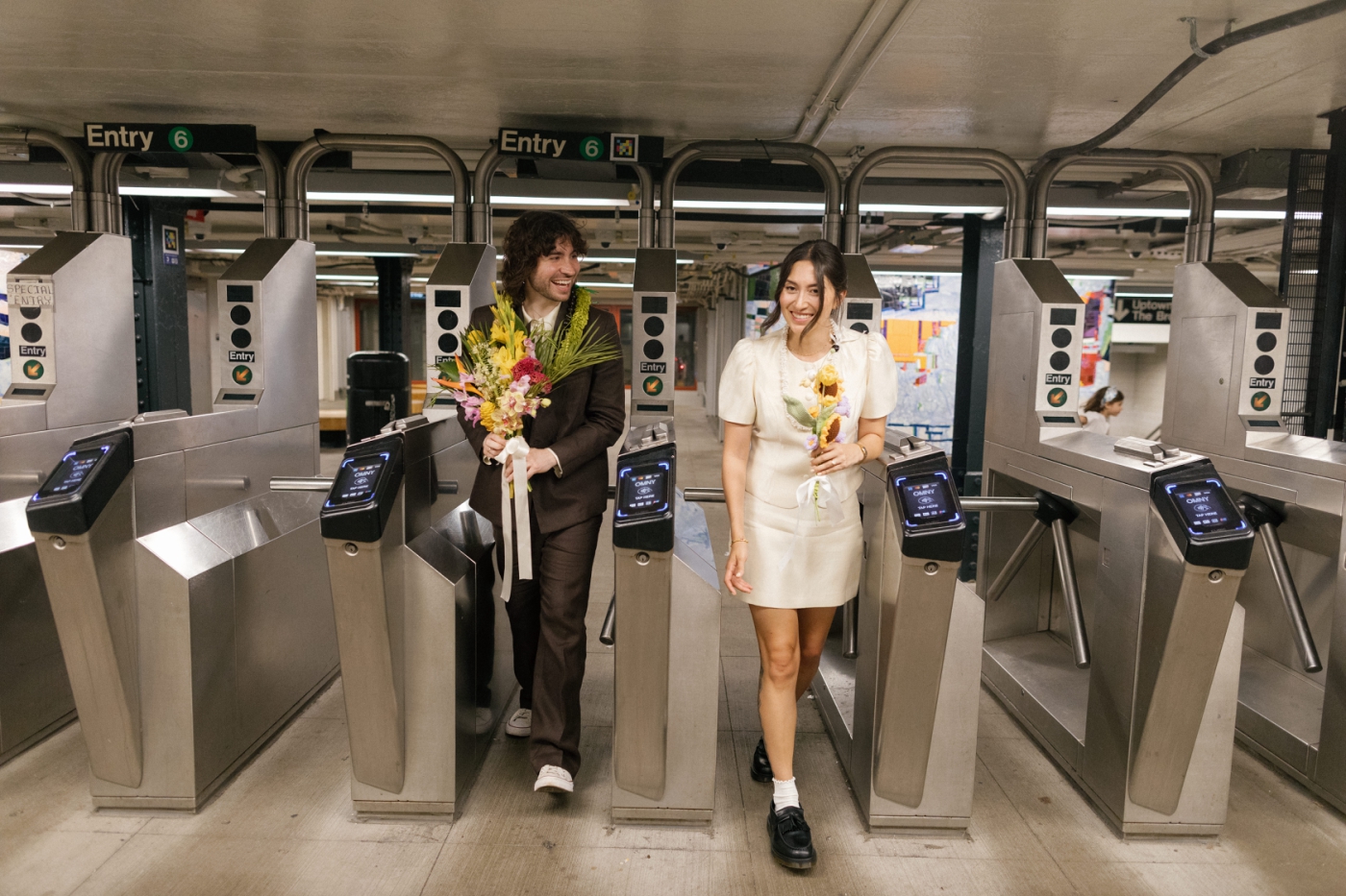 A bride and groom walking through turnstiles