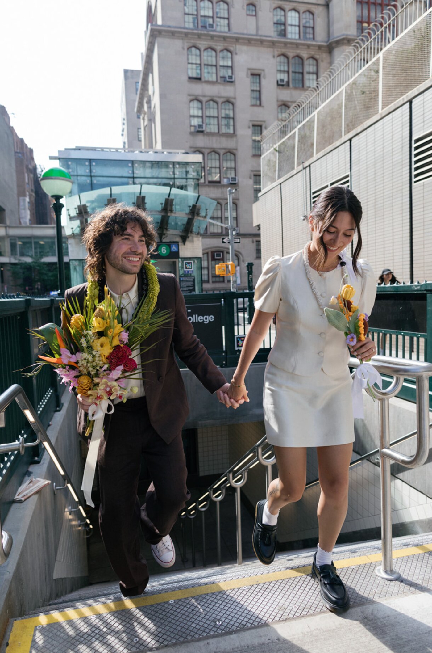 A bride and groom walking out of a subway tunnel in New York City
