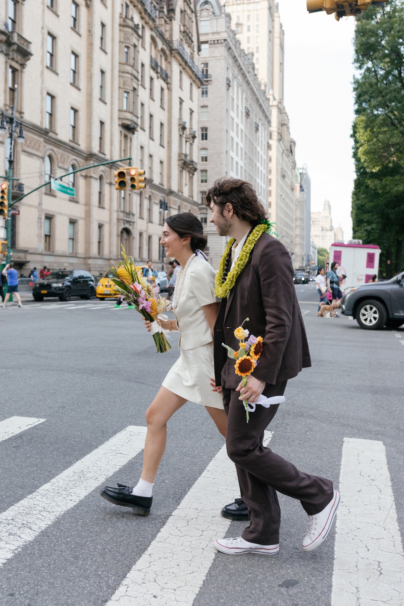 A bride and groom walk across the street in NYC
