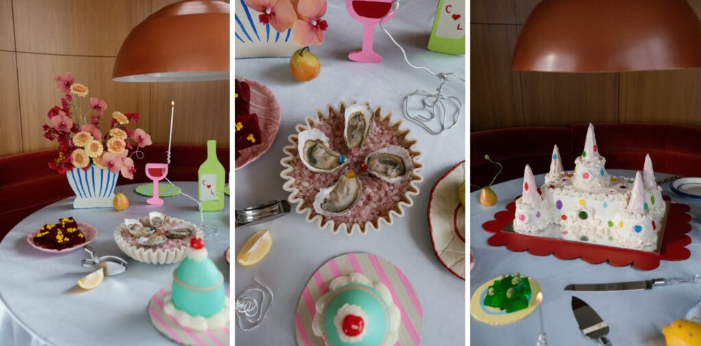 A table-scape with oysters, a cake shaped like a sandcastle, a paper flower pot, and real red and orange flowers